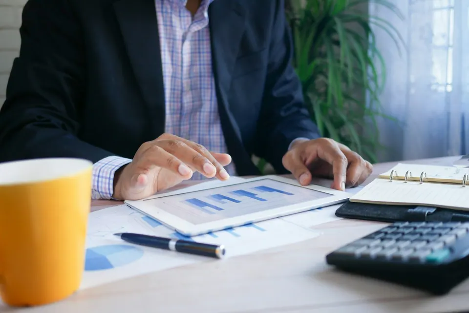 Consultor analisando relatórios financeiros em um tablet
