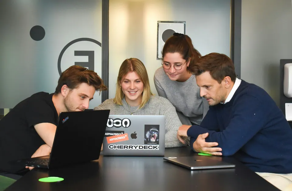 Equipe reunida em volta de um notebook durante a implantação